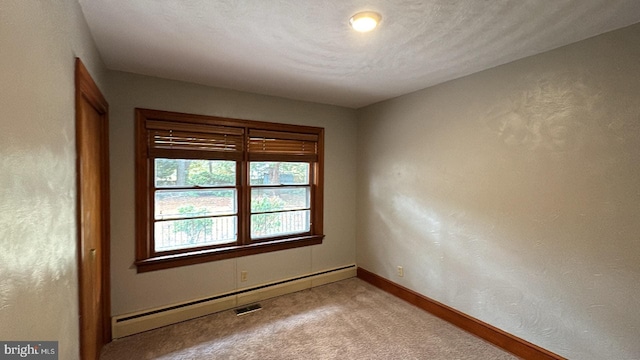 empty room with light carpet, a textured ceiling, and a baseboard heating unit