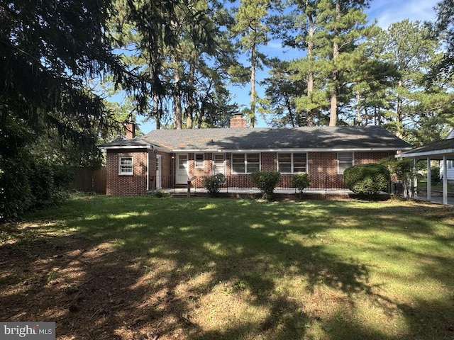 ranch-style house with a carport, a front yard, brick siding, and a chimney