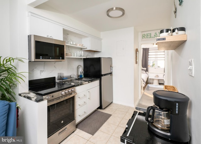 kitchen featuring light tile patterned floors, stainless steel appliances, white cabinetry, and sink