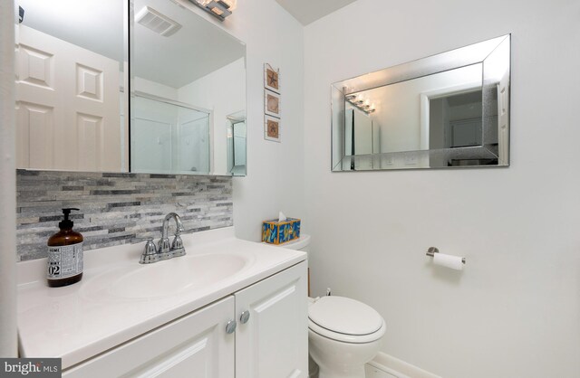 bathroom with vanity, toilet, and backsplash