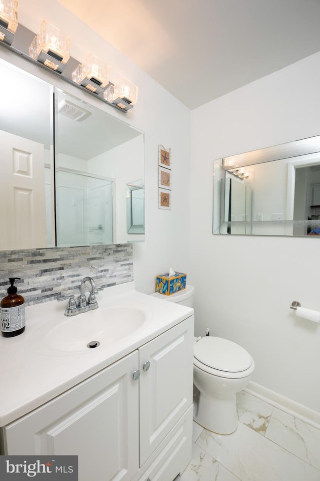 bathroom featuring vanity, toilet, decorative backsplash, and walk in shower