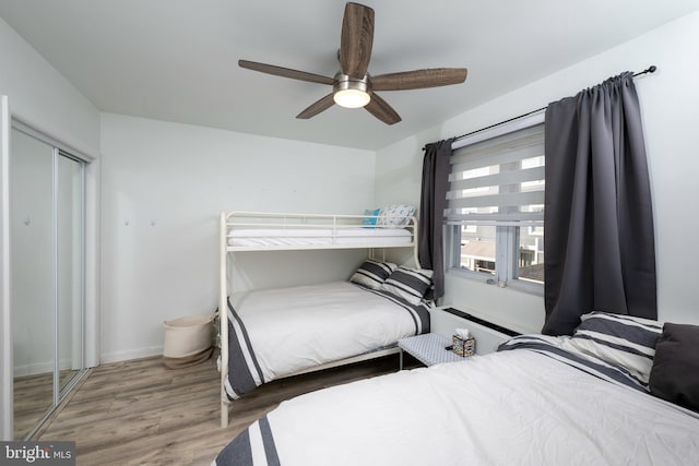 bedroom featuring hardwood / wood-style flooring, ceiling fan, and a closet