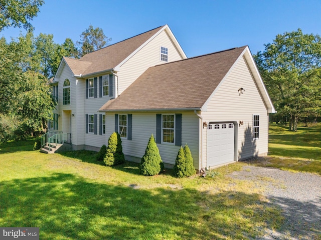 view of front of house featuring an attached garage, a shingled roof, gravel driveway, and a front yard