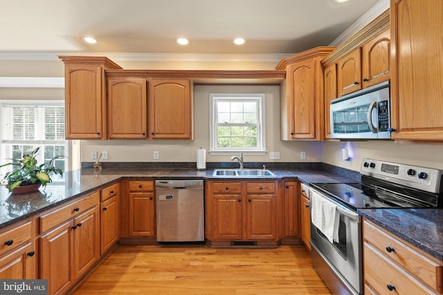 1159 Stoney Bottom Rd, Front Royal, VA 22630 - kitchen with stainless steel appliances, light wood-style flooring, dark stone counters, crown molding, and brown cabinets