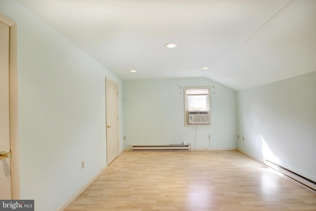 additional living space featuring a baseboard radiator, lofted ceiling, and light hardwood / wood-style floors