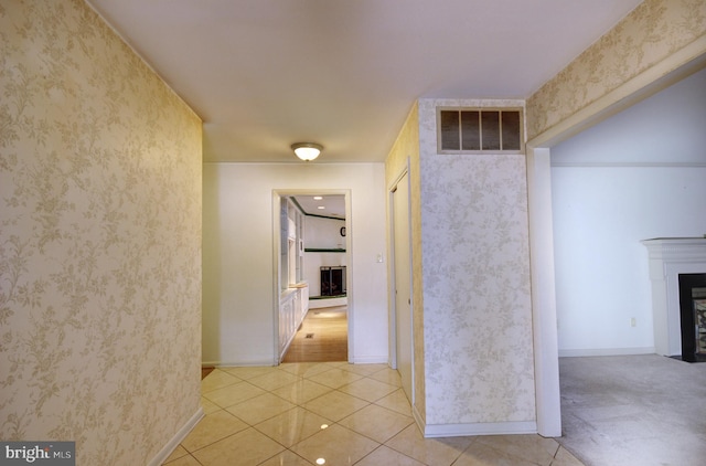 corridor featuring baseboards, light tile patterned flooring, visible vents, and wallpapered walls