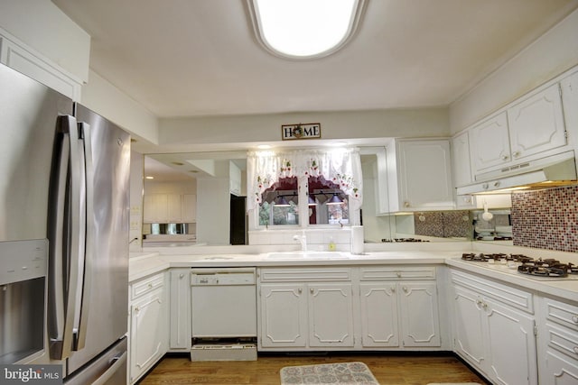 kitchen with dark wood-type flooring, sink, tasteful backsplash, white cabinetry, and white appliances