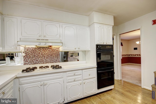 kitchen with white gas cooktop, light wood-type flooring, decorative backsplash, white cabinets, and double oven