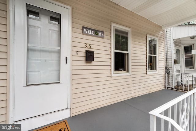 view of exterior entry featuring covered porch