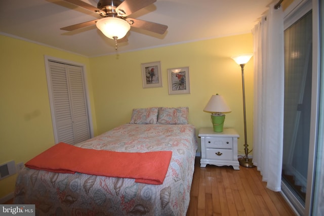 bedroom featuring light hardwood / wood-style flooring, ceiling fan, ornamental molding, and a closet