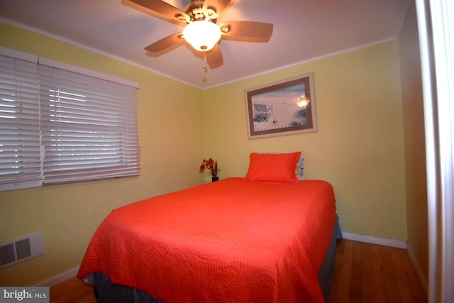 bedroom featuring ceiling fan, dark hardwood / wood-style flooring, and crown molding