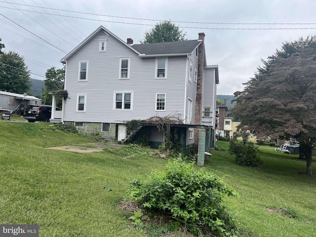 rear view of property featuring a yard