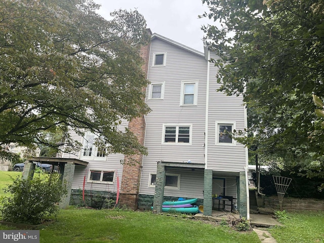 rear view of property featuring a yard