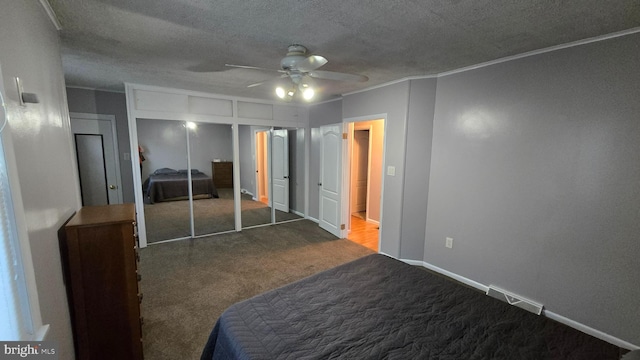 unfurnished bedroom with ceiling fan, a textured ceiling, a closet, and carpet flooring