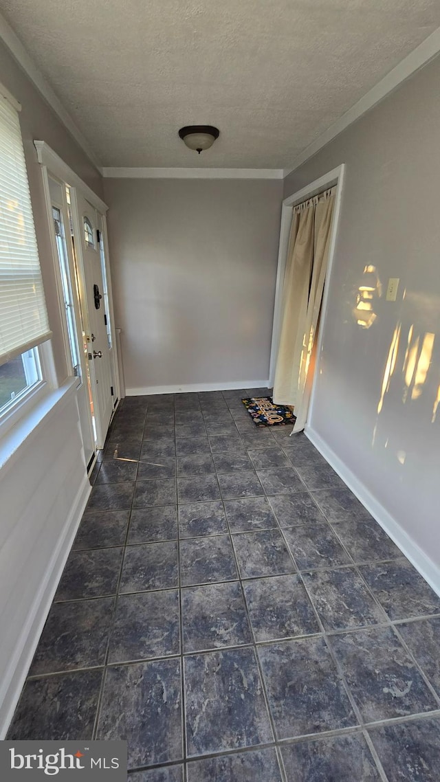 interior space featuring a textured ceiling and crown molding