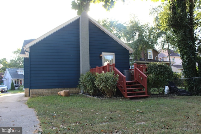 exterior space featuring a deck and a lawn