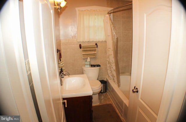 full bathroom featuring vanity, tile walls, shower / bath combo with shower curtain, and toilet