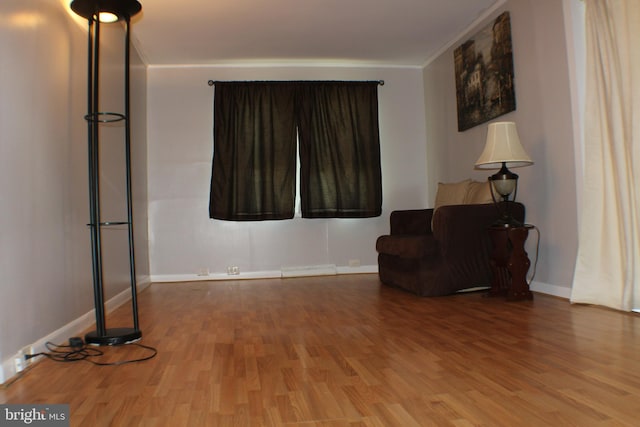 living area featuring ornamental molding and hardwood / wood-style flooring