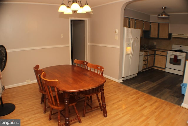 dining area featuring ornamental molding, light hardwood / wood-style floors, and a chandelier