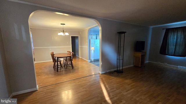 dining room featuring a chandelier, hardwood / wood-style flooring, and crown molding