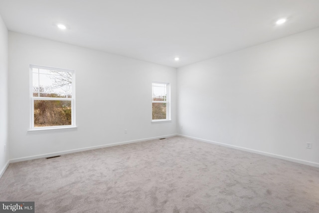 carpeted spare room with recessed lighting, visible vents, and baseboards