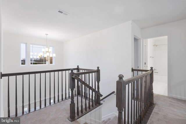 hallway featuring a chandelier and carpet floors