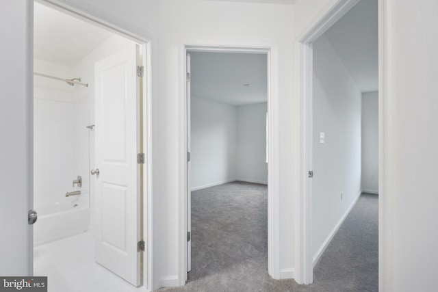 hallway featuring baseboards and carpet flooring