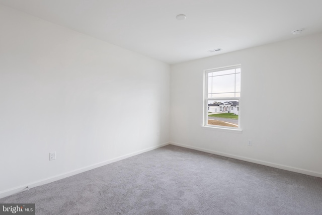 carpeted empty room with visible vents and baseboards