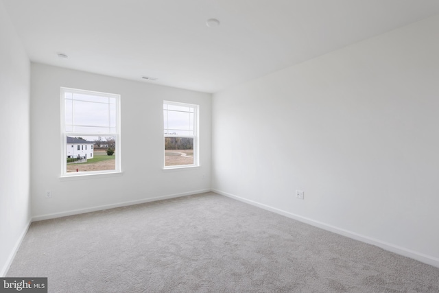 spare room with baseboards and carpet flooring