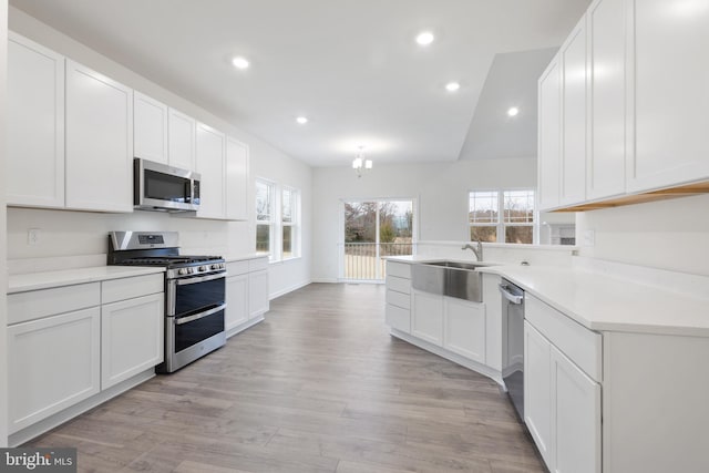 kitchen featuring plenty of natural light, light wood-style floors, appliances with stainless steel finishes, and a sink