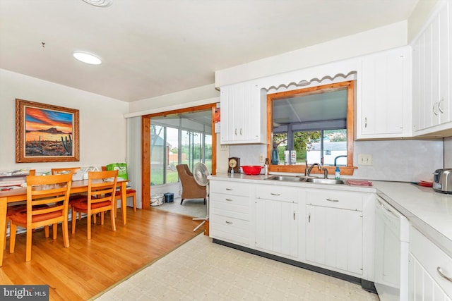 kitchen featuring white cabinets, white dishwasher, sink, and light hardwood / wood-style floors