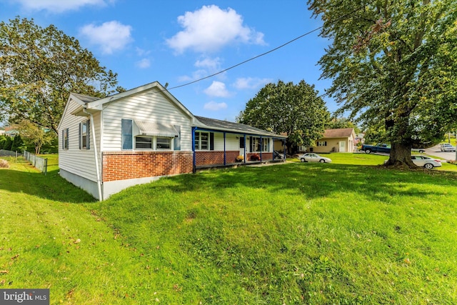 back of property featuring a porch and a lawn