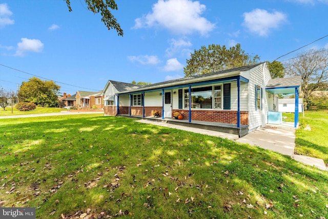 ranch-style house featuring a porch, a front lawn, and a carport