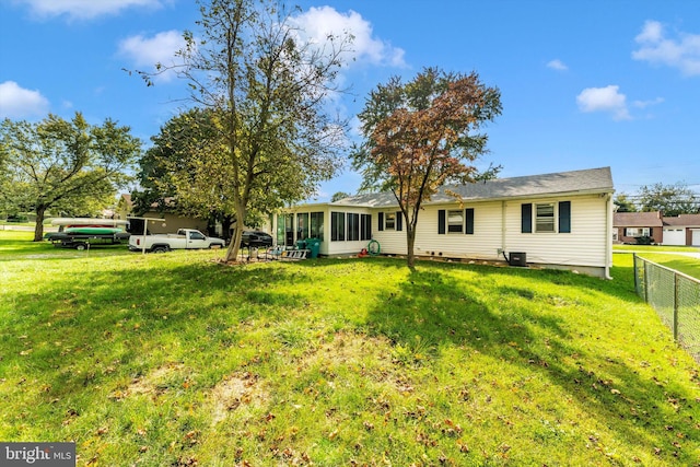 rear view of property with a sunroom and a lawn