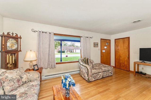 living room featuring light hardwood / wood-style floors and a baseboard heating unit