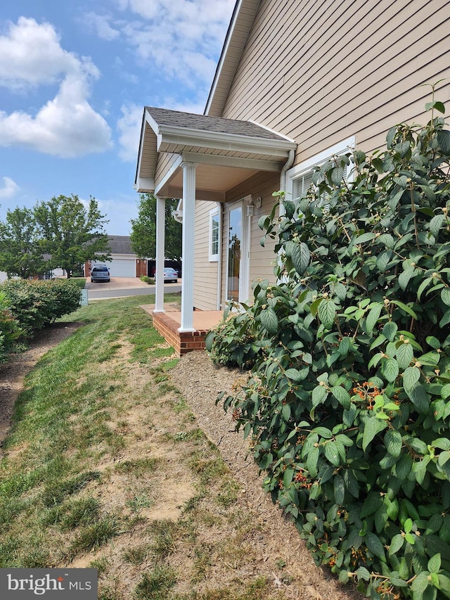 view of yard featuring a garage and covered porch