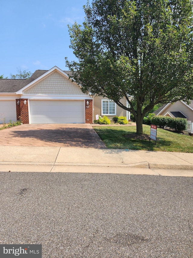 view of front of house with a garage and a front lawn