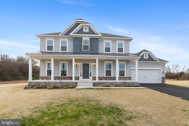 view of front of house featuring a porch, a garage, and a front yard