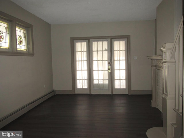 interior space with a wealth of natural light, a baseboard radiator, and dark hardwood / wood-style floors