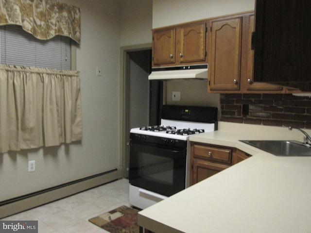 kitchen featuring baseboard heating, gas range gas stove, and sink