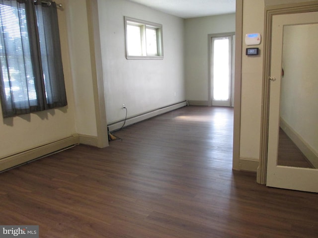 spare room featuring a baseboard radiator and dark hardwood / wood-style floors