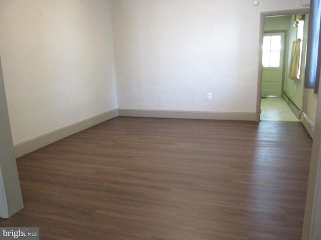 empty room with dark hardwood / wood-style flooring