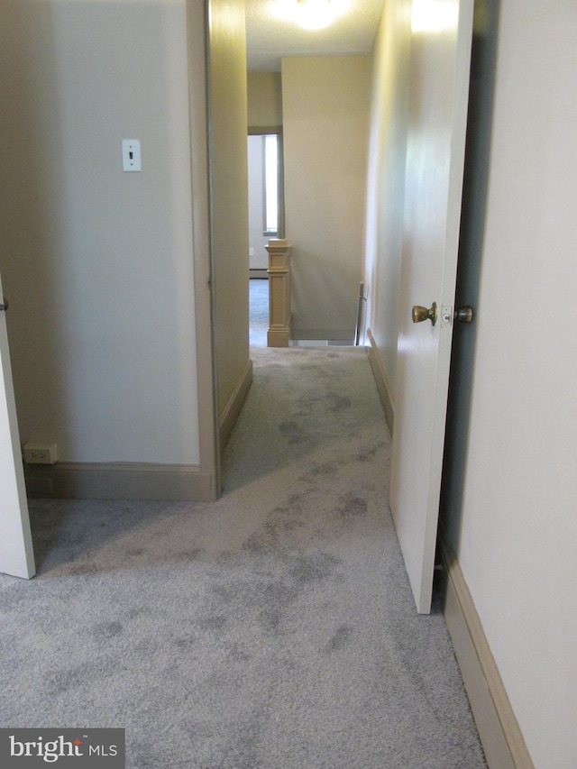 hallway featuring light colored carpet