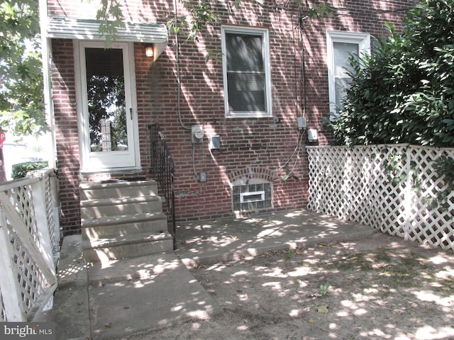 view of exterior entry with a patio