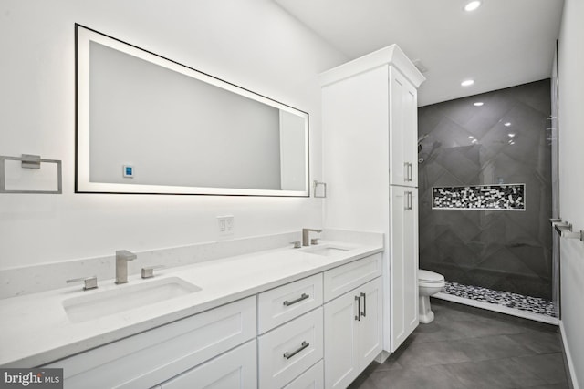 bathroom featuring toilet, a shower stall, a sink, and recessed lighting