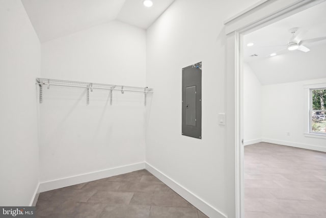 spacious closet featuring lofted ceiling, electric panel, and a ceiling fan