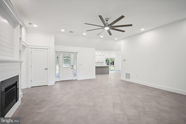 unfurnished living room featuring a large fireplace and ceiling fan