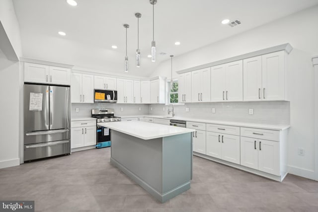 kitchen featuring a center island, tasteful backsplash, light countertops, appliances with stainless steel finishes, and white cabinetry