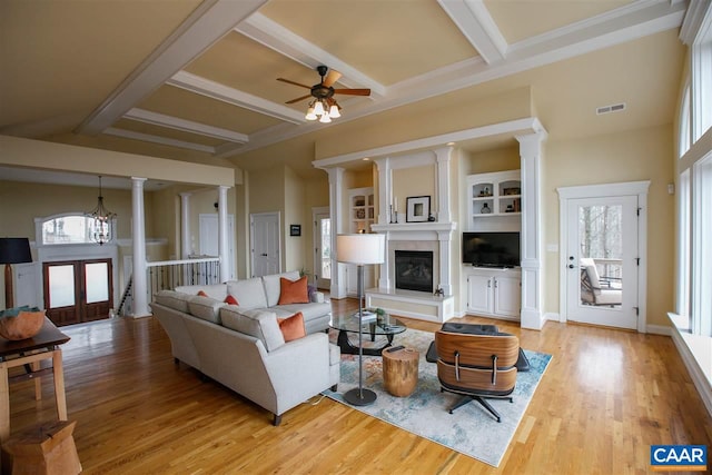 living area with a healthy amount of sunlight, visible vents, and ornate columns