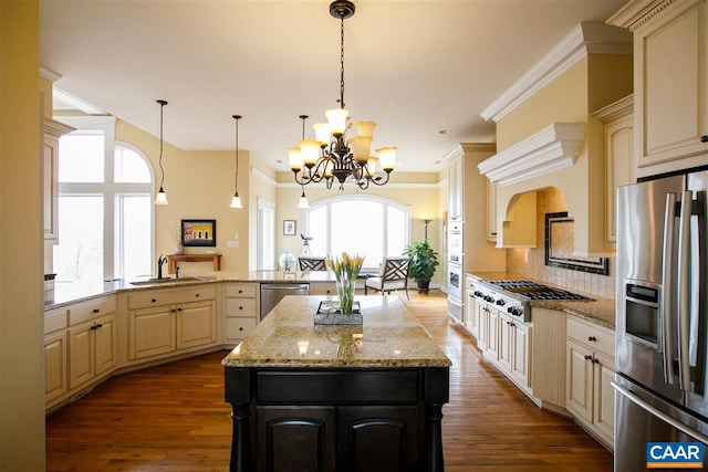 kitchen featuring stainless steel appliances, a center island, a sink, and cream cabinets